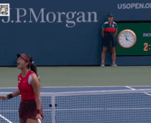a woman is holding a tennis racquet in front of a sign for the us open
