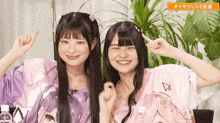 two girls are standing next to each other with a sign that says # live on it