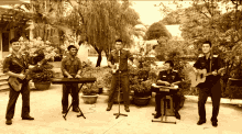 a group of men playing instruments including a keyboard and a guitar