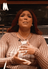 a woman with red hair is wearing a plaid shirt and necklace