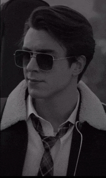 a black and white photo of a man wearing sunglasses and a tie