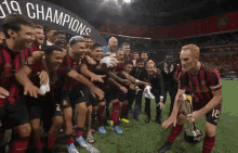 a group of soccer players are posing for a picture in front of a banner that says " 19 champions "