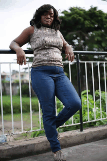 a woman leaning on a railing with her hands on her knees