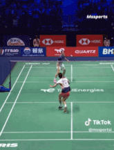 a badminton court with advertisements for hsbc quartz and canten