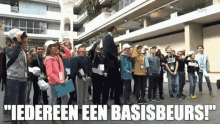 a group of children are standing in front of a building with the words " iedereen een basisbeurs " above them