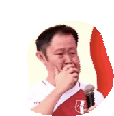 a man is crying while holding a microphone and wearing a peruvian jersey .