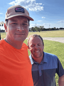 two men are posing for a picture with one wearing an orange shirt that says teeriders