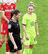 a female referee stands next to a female soccer player wearing a green shirt with the number 10 on it .