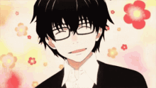 a boy with glasses is smiling with flowers in the background