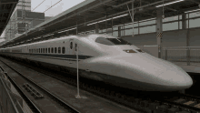 a bullet train is parked on the tracks at a train station