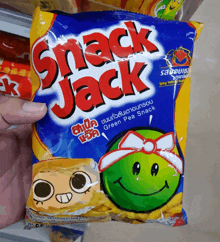 a person holding a bag of snack jack green pea snack