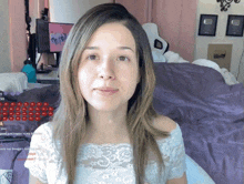 a woman in a white lace top sits in front of a computer monitor