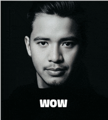 a black and white photo of a man 's face with the word wow below him