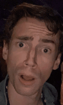 a close up of a man making a surprised face