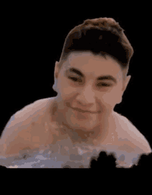 a shirtless man is swimming in a pool with a black background .