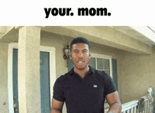 a man in a black shirt stands in front of a house with the words " your mom " written above him