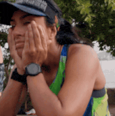 a woman wearing a watch and a visor with the word marathon on it covering her face