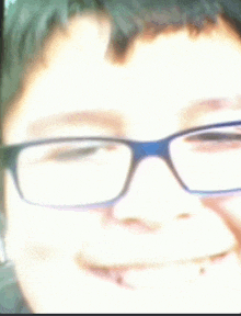 a close up of a young boy wearing glasses .