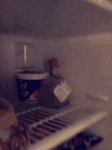 an empty refrigerator with a cup of cool whip on the shelf