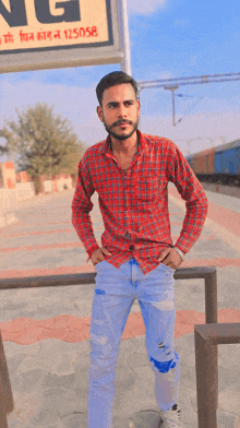 a man in a plaid shirt stands in front of a sign that says 125058