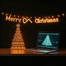 a laptop with a christmas tree on the screen and a merry christmas banner above it