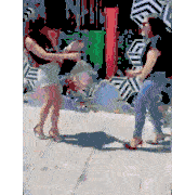 two women are standing next to each other on a sidewalk and fighting .