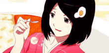 a girl in a pink kimono is holding a spoon in her hand