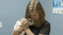 a woman is holding a rabbit in front of a poster that says ' female diseases in dog and cat '