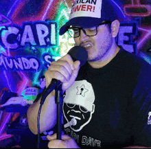 a man singing into a microphone wearing a shirt that says cari dave