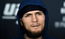 a man with a beard wears a blue hoodie and a black headband