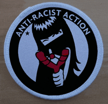 a round patch that says anti-racist action on it