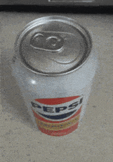 a can of pepsi sits on a table with the lid open