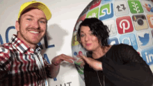 a man and a woman are posing for a picture in front of a globe with social media icons on it