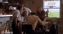 a group of people gathered around a table in a restaurant with a sign on the wall that says ' no smoking '