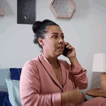 a woman in a pink robe is talking on her cell phone