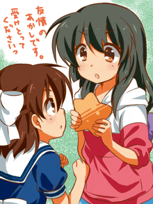 a girl in a pink shirt is holding a piece of bread next to another girl