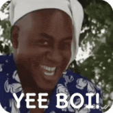 a man wearing a bandana on his head is smiling and says yee boi .