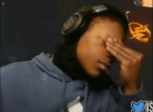 a person wearing headphones is rubbing their forehead .