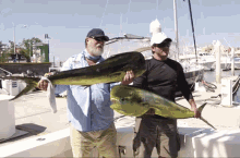 two men holding a large fish in front of a boat with a sign on it that says ' fishing '