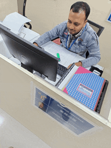 a man is sitting at a desk with a dell computer