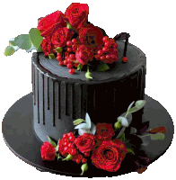 a black cake with red roses and berries on it