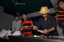 a man wearing a straw hat holds a container of food