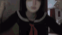 a girl in a sailor suit with a red tie is standing in a dark room .