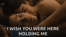 a man and a woman are laying next to each other on a bed and the woman is holding the man 's arm .