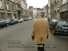 a man walking down a street with the words ik sta op and ik trek je hoofd eraf jongen