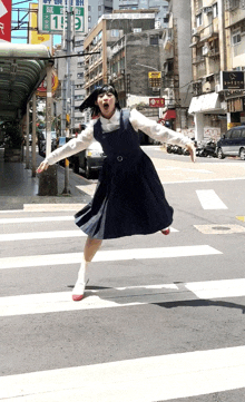 a girl in a school uniform is jumping over a crosswalk in front of a sign that says 8 & 9