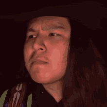 a man with long hair is wearing a cowboy hat with the word wisdom written on it