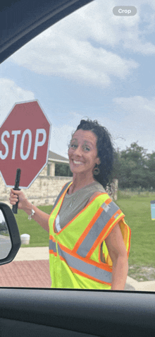 a woman is holding a stop sign in her hand