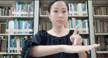 a woman stands in front of a bookshelf with a book titled ' a brief history of the world '