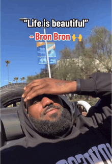 a man with a beard is laying in a car with a caption that says life is beautiful